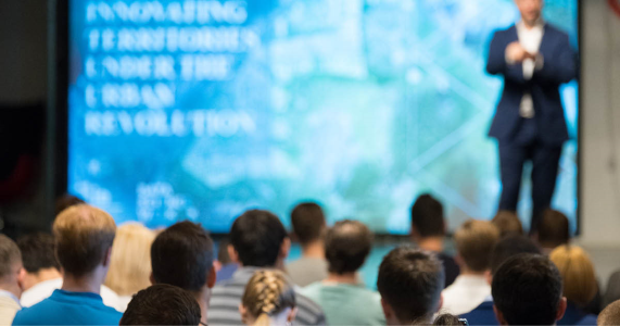 Group of event attendees listening to an event sponsor keynote